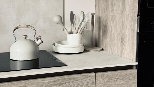 Una cucina moderna con un bollitore, un portautensili e un fornello.