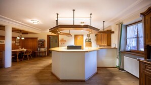 Una cocina amplia con una isla central, armarios de madera y un comedor con mesa y sillas.