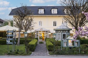 A building with a cafe and restaurant sign, a cobblestone path, and a small gazebo. - Großzügiges Studio in Bad Birnbach (Bad Birnbach)
