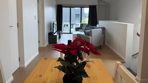 Un salon moderne avec une table à manger en bois, une plante en pot et un canapé.