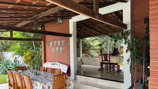Eine Terrasse im Freien mit einer Ziegelwand, einem Tisch mit Stühlen und einem Grill.