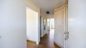 A hallway with wooden flooring, white walls, and a door with a number plate. - Großes Studio am Kurpark in Bad Birnbach mit Balkon (Bad Birnbach)
