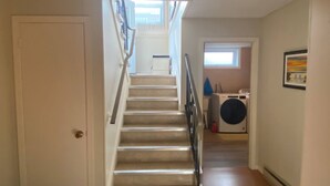 A staircase leading to a laundry area with a washing machine and a window. - Vermaurel Sweet Lodge (Bathurst)