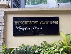 Ein Schild mit der Aufschrift 'Winchester Gardens' und dem Slogan 'Wunderbare Häuser'.
