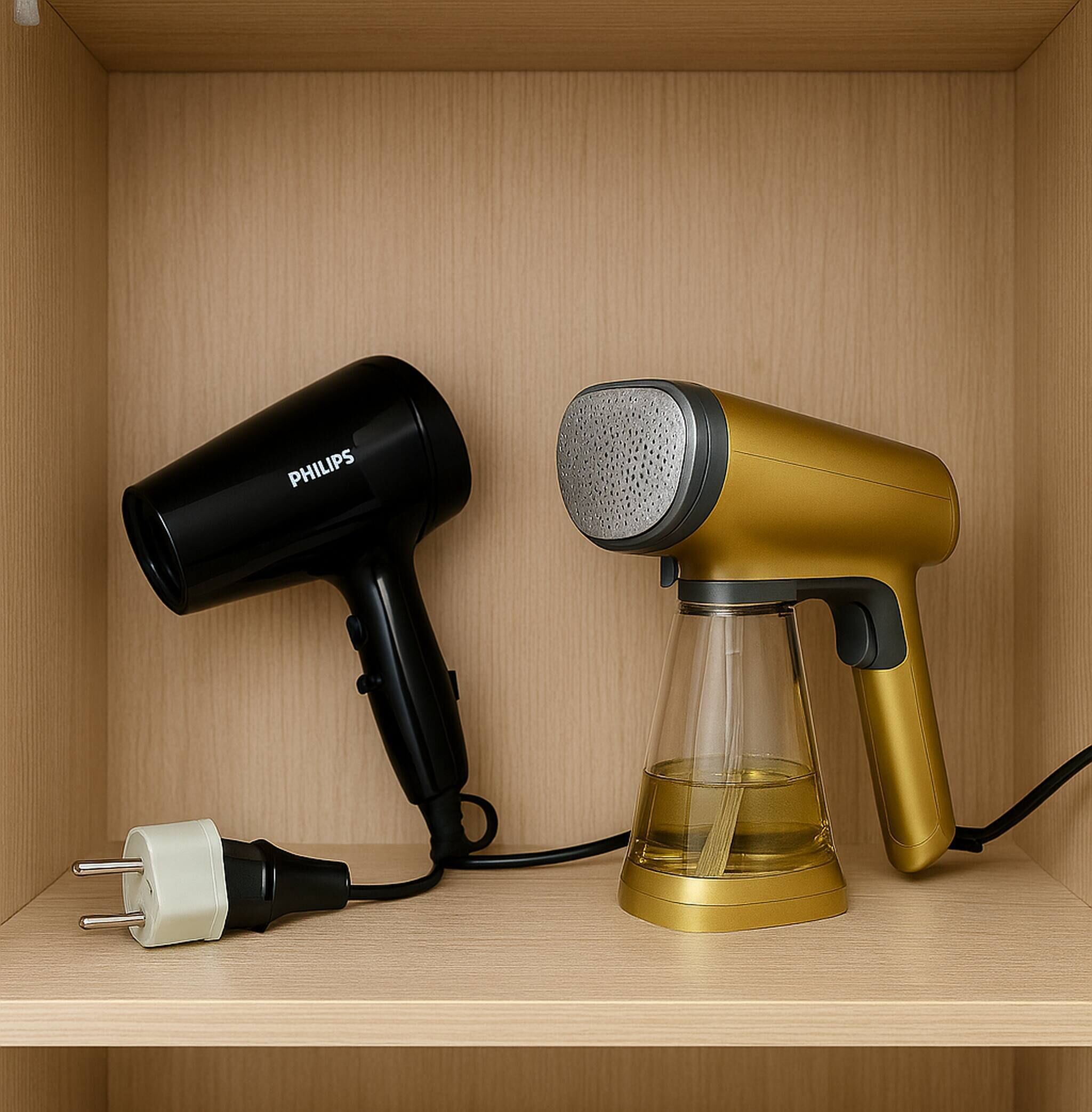 Een haardroger en een speaker staan op een plank.