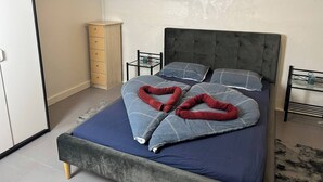 A bedroom with a bed, a dresser, and a chair. - Basement Apartment in Villa (Odense)
