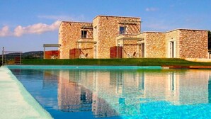 Un edificio de piedra con una piscina delantera.