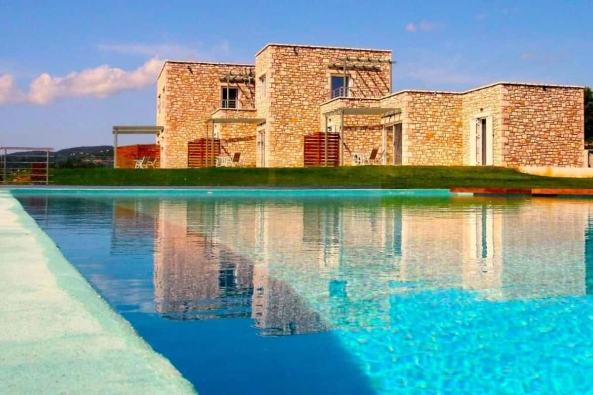 A stone building with a swimming pool in front.
