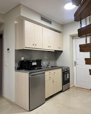 Una cocina funcional con lavavajillas, estufa y cafetera.