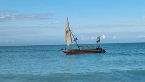 Een strand met een boot in het water en een zandstrand.