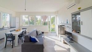 A modern kitchen with a dining area, large windows, and a built-in TV. - Holiday Home in 	Mazara del Vallo (Mazara del Vallo (TP))