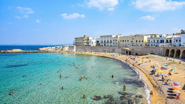 A coastal town with a clear beach, people swimming, and white buildings with arches. - Apartment in Torre Suda, Racale (Torre Suda Provincia Lecce)