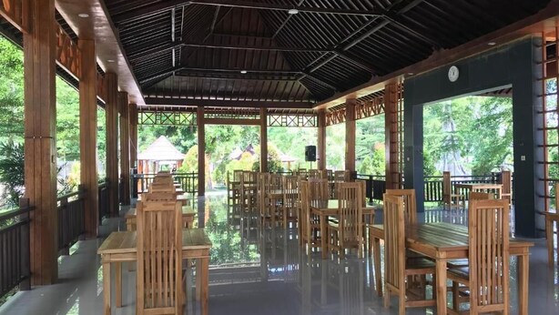 An indoor wooden pavilion with a tiled floor and a view of greenery outside. - Pohon Purba Resort & Restaurant (Labuhan Lombok)