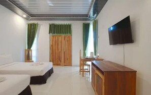 Una habitación de hotel con cama, escritorio, silla, televisor y cortinas.