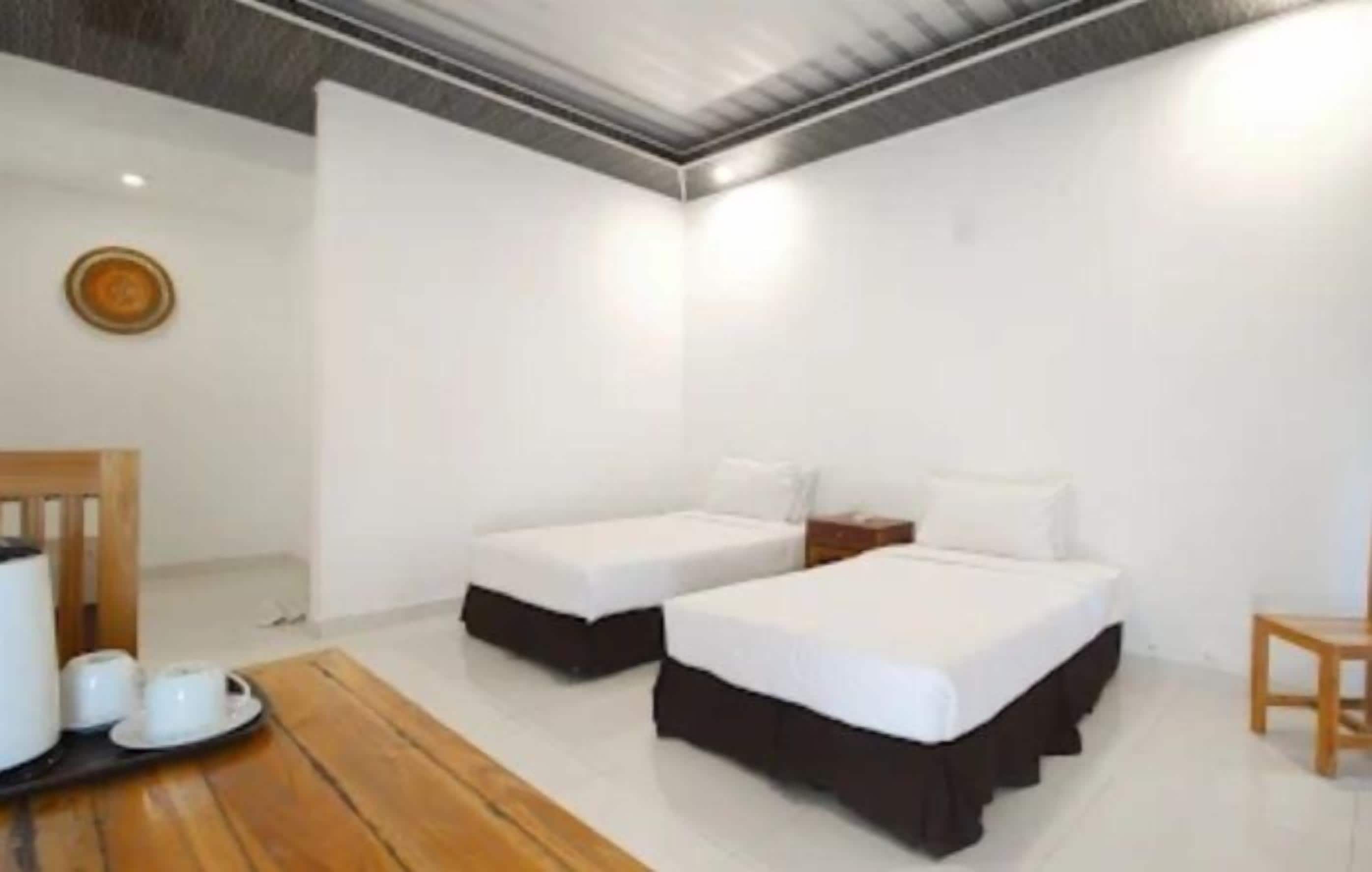 Une chambre avec deux lits, une table en bois et une petite chaise.