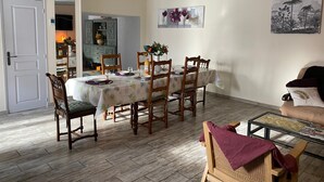 A dining area with a table set for four, wooden chairs, and a glass coffee table.