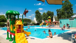 Un espace piscine comprenant une structure de jeux aquatiques et un toboggan.