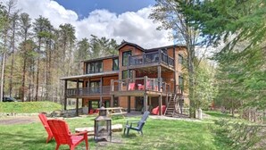 Eine zweistöckige Hütte mit Balkon, umgeben von einem Wald.