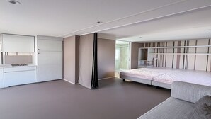 Een moderne slaapkamer met een bed, een bureau en een kledingkast.