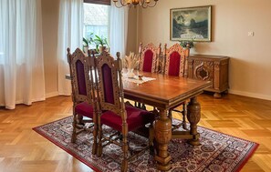 A dining room with a wooden table, ornate chairs, and a patterned rug. - 4 bedroom beautiful home in Glemmingebro (Glemmingebro)