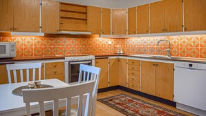 A kitchen with wooden cabinets, a microwave, an oven, a sink, and a dishwasher. - 4 bedroom beautiful home in Glemmingebro (Glemmingebro)