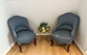 Two armchairs with a speckled pattern, a small round table with a plant, and wooden flooring. - 4 bedroom beautiful home in Glemmingebro (Glemmingebro)