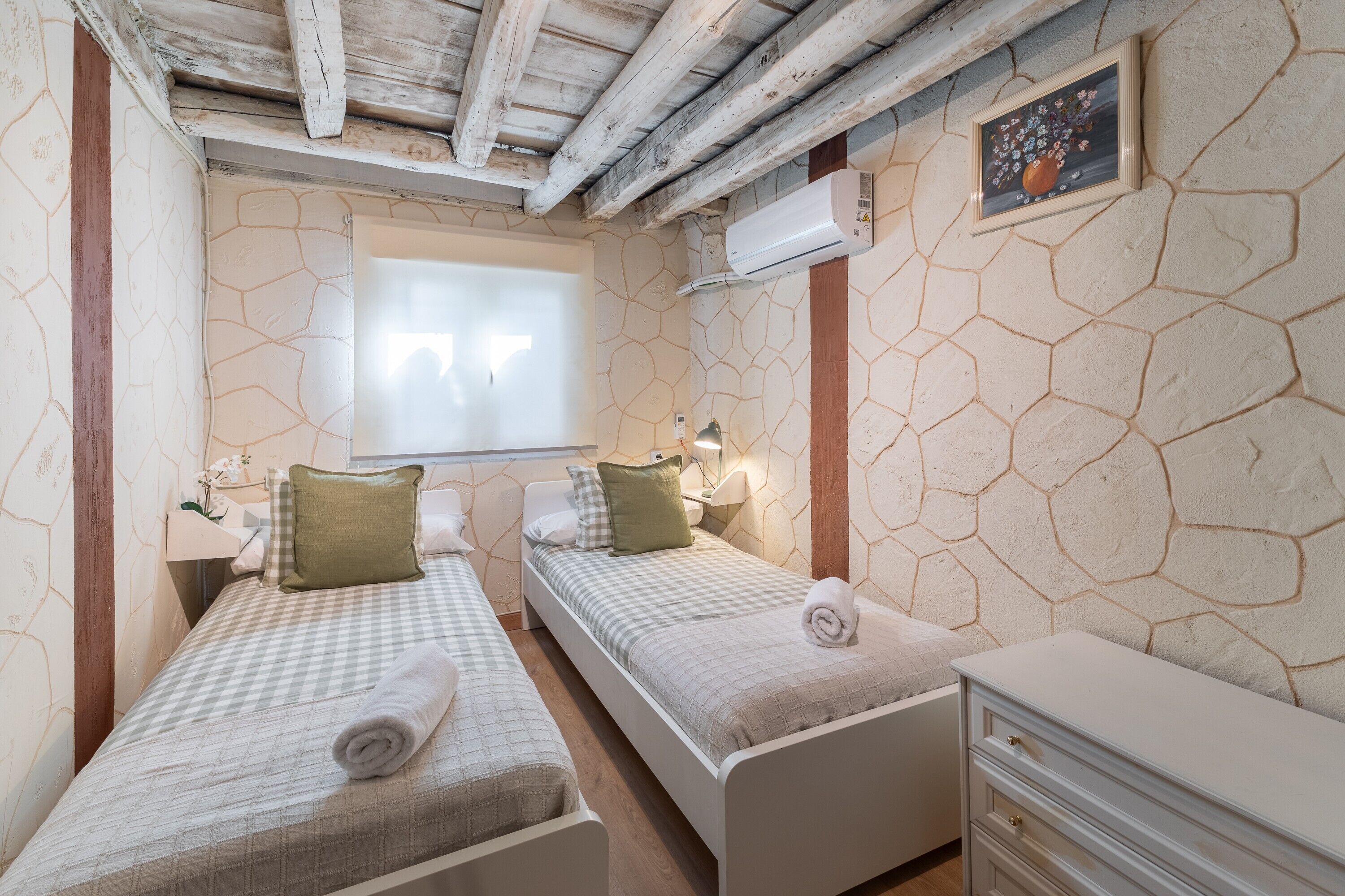 Una habitación con dos camas, un aparador, una ventana con vistas y aire acondicionado.