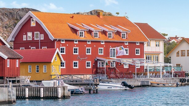 A red building with a white window trim, a yellow building, and a white building with a red roof. - Awesome apartment in Kyrkesund with WiFi (Kyrkesund)