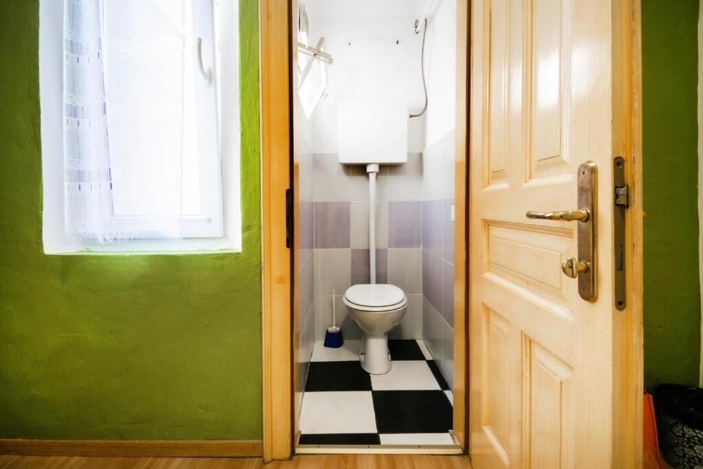 Baño pequeño con inodoro, ducha y ventana.