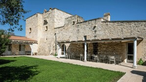 Un edificio in pietra con una veranda coperta e posti a sedere all'aperto.