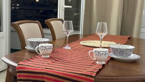 Mesa posta com tigelas estampadas, copos e um jogo de mesa listrado.