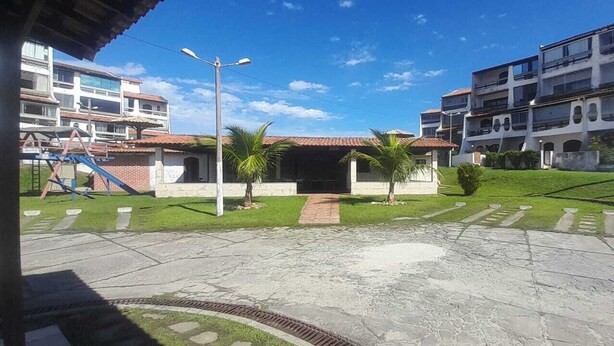 Un patio central con un sendero, rodeado de edificios con balcones y un parque infantil.