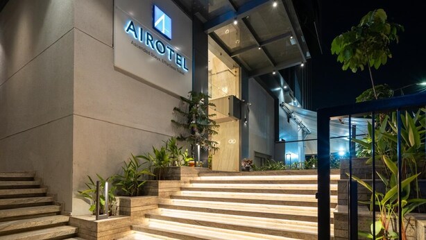 A modern hotel entrance with a sign reading "AIROTEL" and a staircase leading to the entrance. - Airotel (Pune)