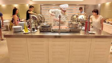 A buffet setup with multiple serving stations, a central cooking area, and a variety of food items and condiments.