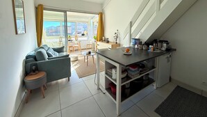 Ein kompakter Wohnraum mit Küchenzeile, Essbereich und Sofa.