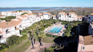 Ein Resort mit mehreren Gebäuden, einem Schwimmbad und Blick auf die Küste.