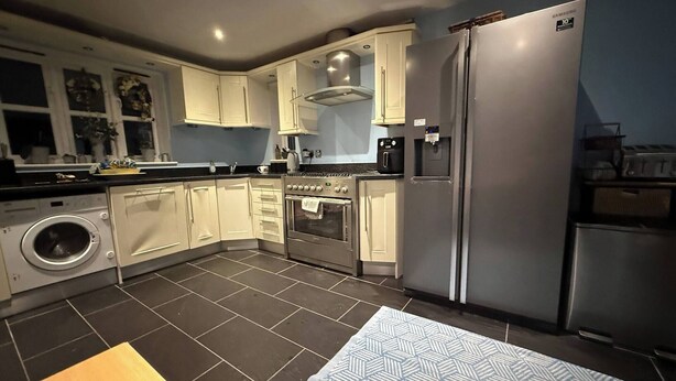 A modern kitchen with a stainless steel refrigerator, oven, and washing machine. - Room-charming Cottage Room With Garden V (Bedford)