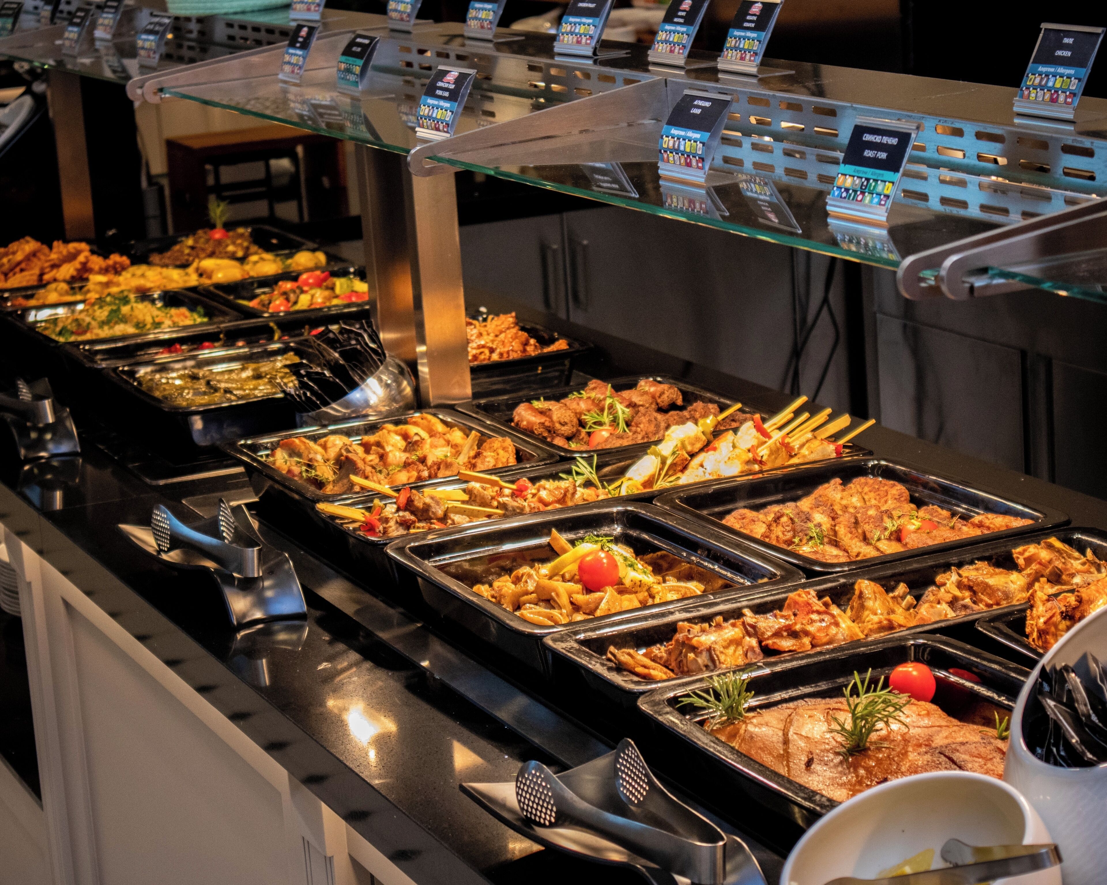 A buffet with various food options and a glass display case above.