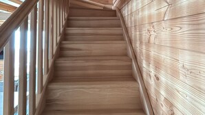 Eine Holztreppe mit Handlauf, die nach oben führt.