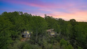 Ein abgelegenes Haus, umgeben von dichtem Wald, mit einer sichtbaren Terrasse und einer kleinen Veranda.