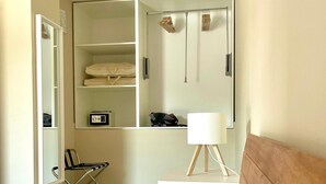 A bedroom with a bed, a bedside table with a lamp, a chair, a desk, and a wardrobe. - Gianna House and Choirs (Sicilia)