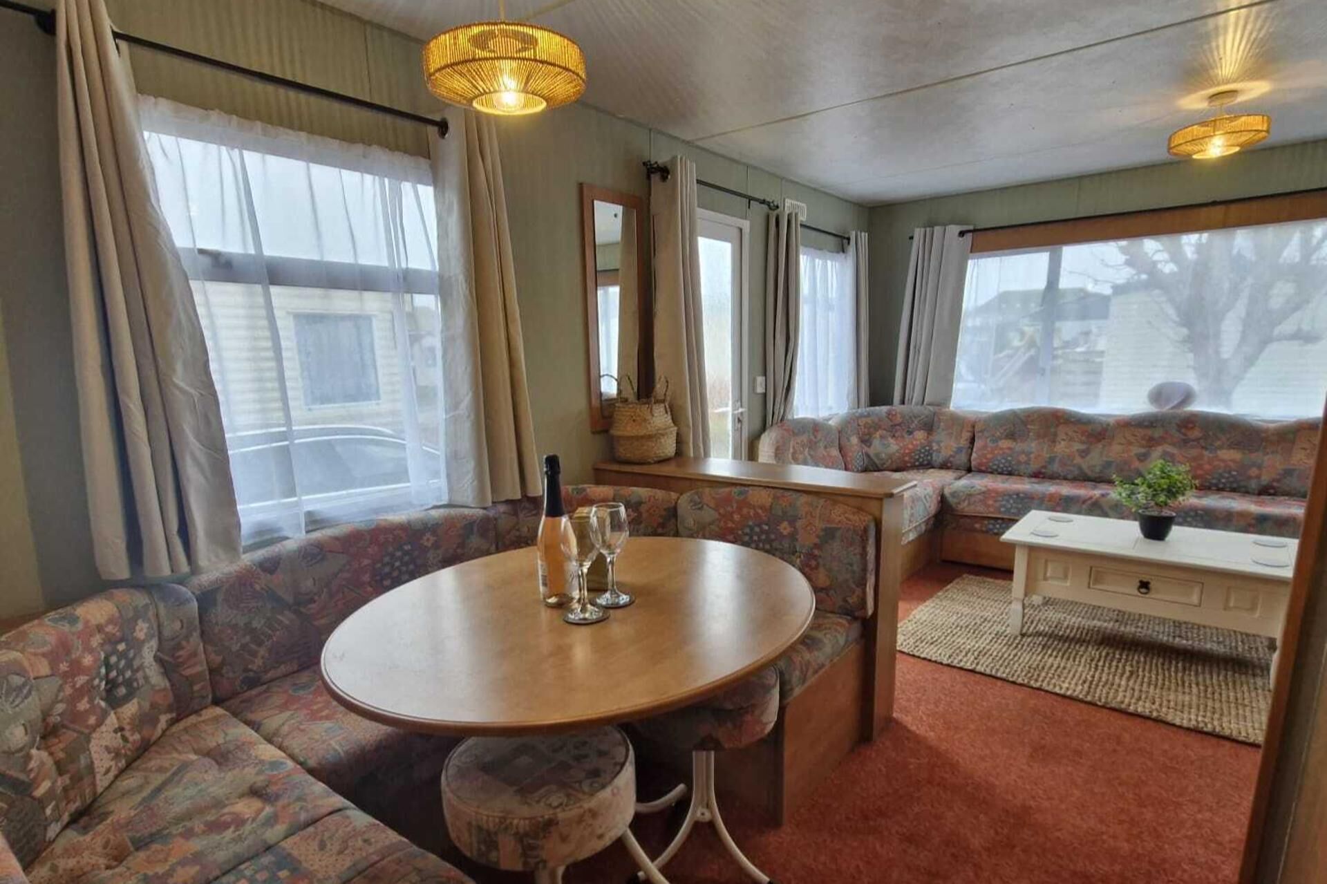 A cozy room with a round table, a sofa, and a small cabinet.