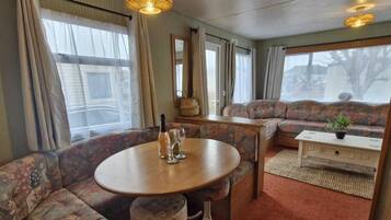 A cozy room with a round table, a sofa, and a small cabinet.