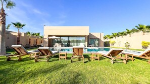 A modern pool area with wooden loungers and a clear view of the pool. - Magnificent villa Agathe with heated swimming pool (Marrakech)