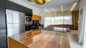 Eine moderne Küche mit Kochinsel, integrierten Geräten und einem Essbereich mit Sofa und Tisch.