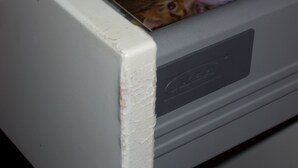 Un gros plan sur un coin de mur blanc où l’on peut voir une fissure.