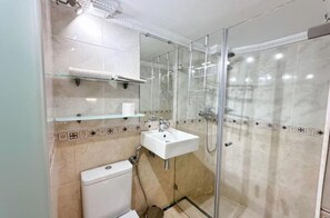 A bathroom with a glass-enclosed shower, a white sink, and a toilet. - Charming 1-bedroom Apartment in Marbella, Spain (Marbella)