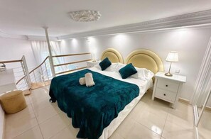 A hotel room with a large bed, a nightstand, a lamp, and a view of the balcony. - Charming 1-bedroom Apartment in Marbella, Spain (Marbella)