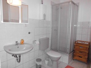Un baño con lavamanos, inodoro y ducha.
