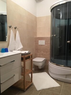 Ein Badezimmer mit Dusche, Toilette und Waschbecken.